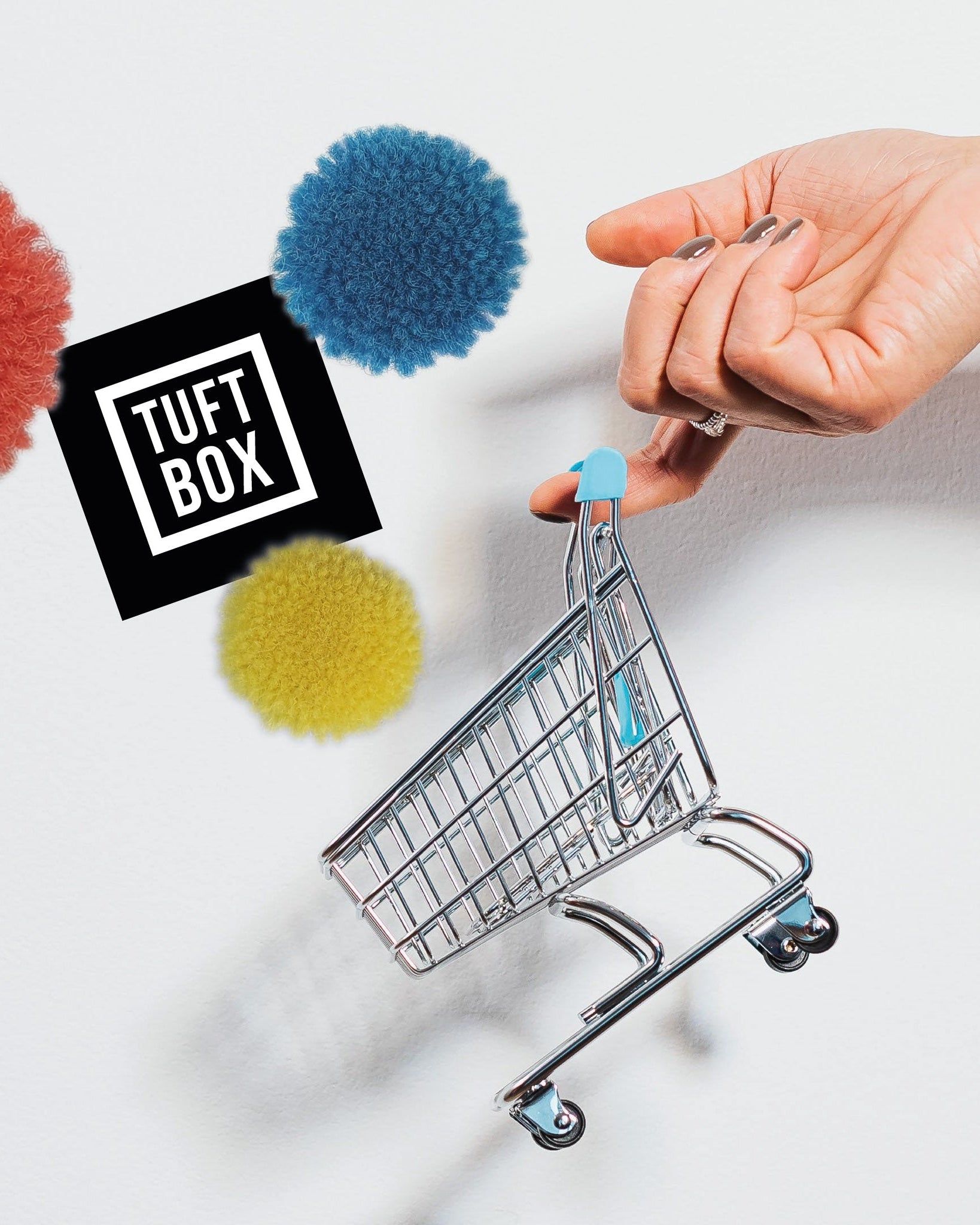 A mini shopping cart being filled with fluffy pompoms