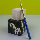 Blue Punch Needle leaning on little concrete cubes