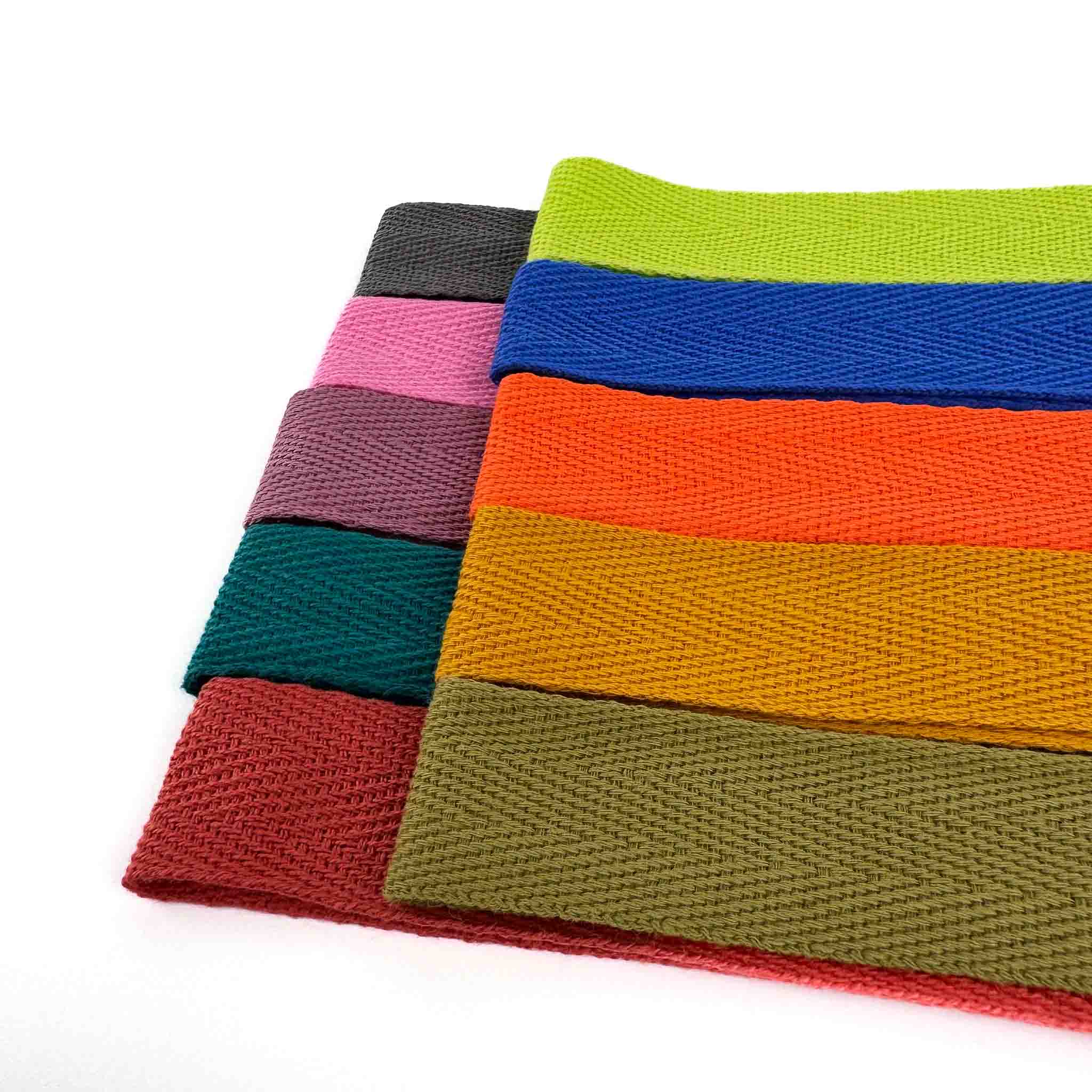 Colorful woven cotton herringbone rug binding webbings on a white background