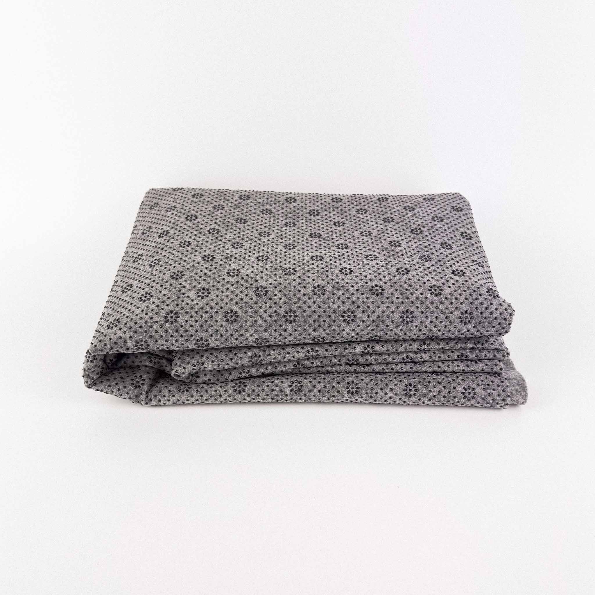 Folded gray non slip tufting fabric with a pattern on a white background