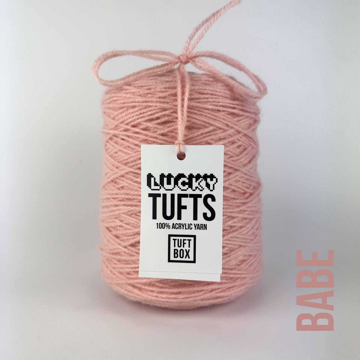 A cone of Lucky Tufts™ acrylic tufting and punch needle yarn in the colour babe a light pink
