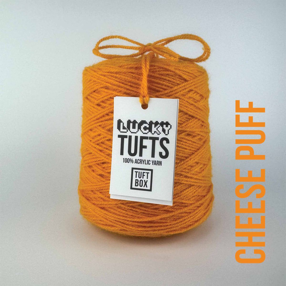 A cone of Lucky Tufts™ acrylic tufting and punch needle yarn in the colour Cheese Puff a bright saturated orange