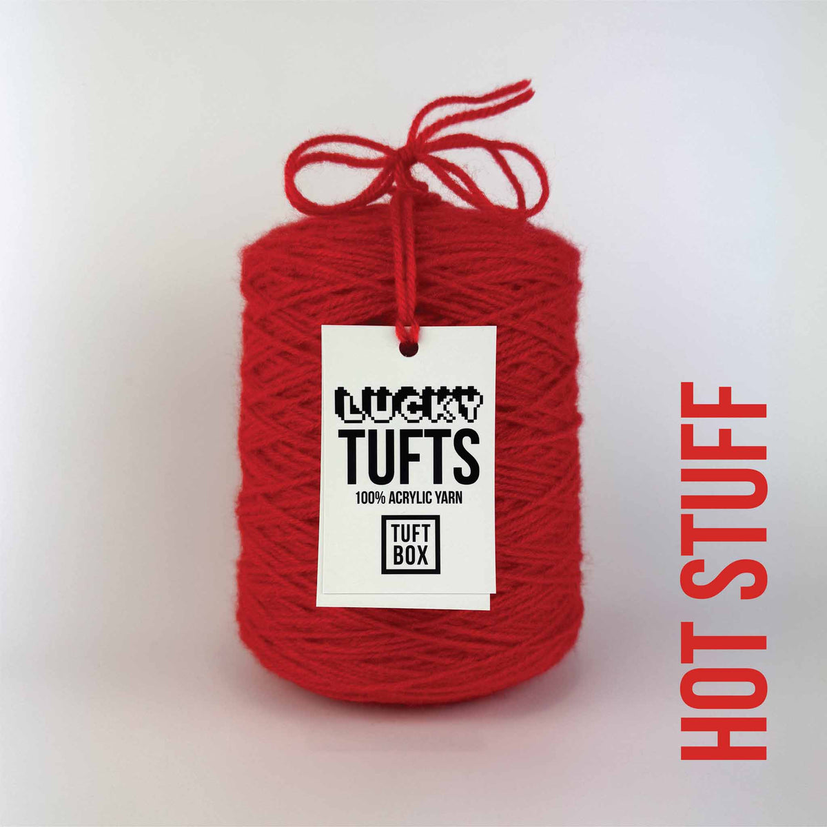 A cone of Lucky Tufts™ acrylic tufting and punch needle yarn in the colour Hot Stuff a very bright lively red