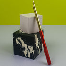 Red Punch Needle leaning on little concrete cubes