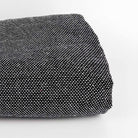 Standard Black and White Woven rug tufting secondary fabric folded in a roll on side with white background