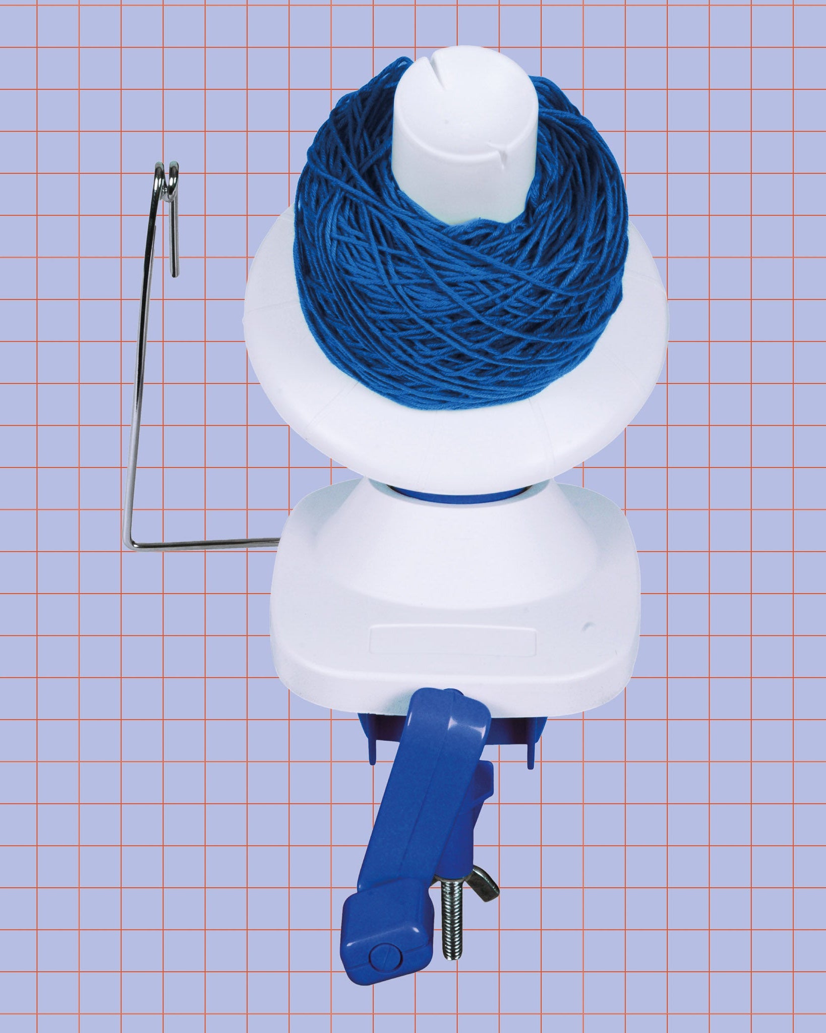 white manual yarn winder with blue yarn on purple grid background