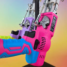 Close-up of Tuftbox AK-5 Rug Tufting Gun. Both Models Hanging From A Display Stand Showing Two Different Colour Varients: Purple Glow And Fire Pink