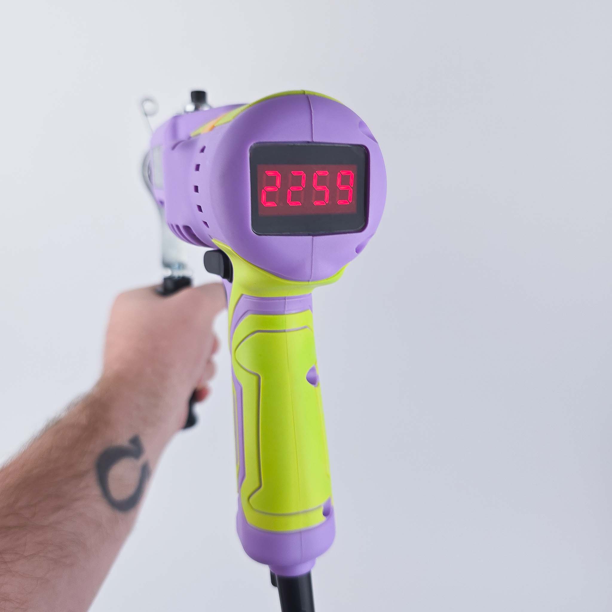 Digital speed display of the AKV AK5 rug tufting machine being held in air on white background screen showing RPM of 2259