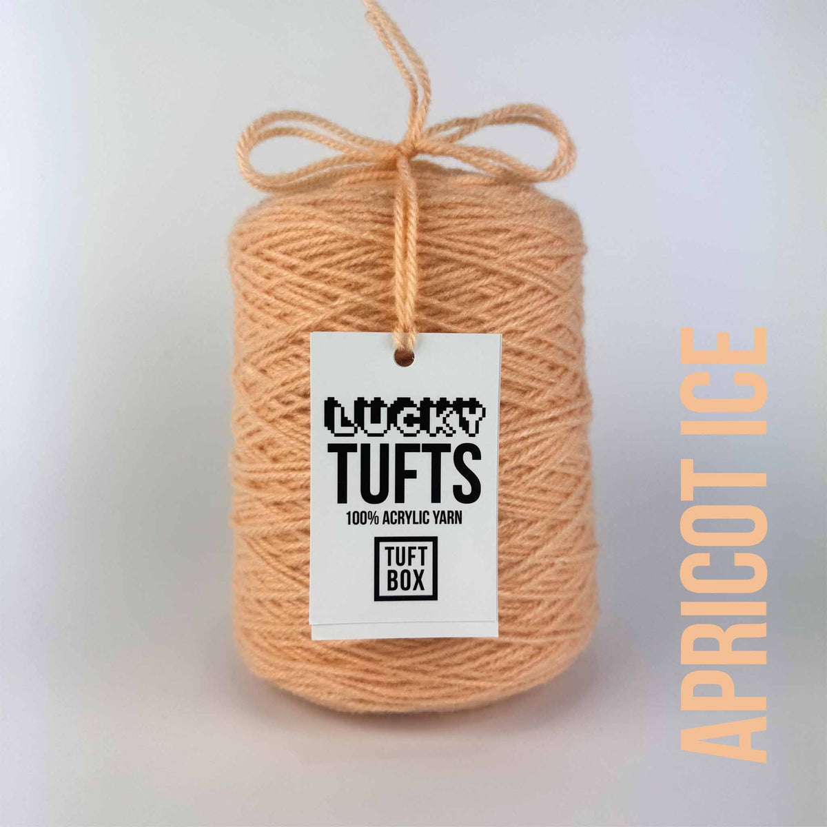 A cone of Lucky Tufts™ acrylic tufting and punch needle yarn in the colour Apricot Ice a light pastel orange