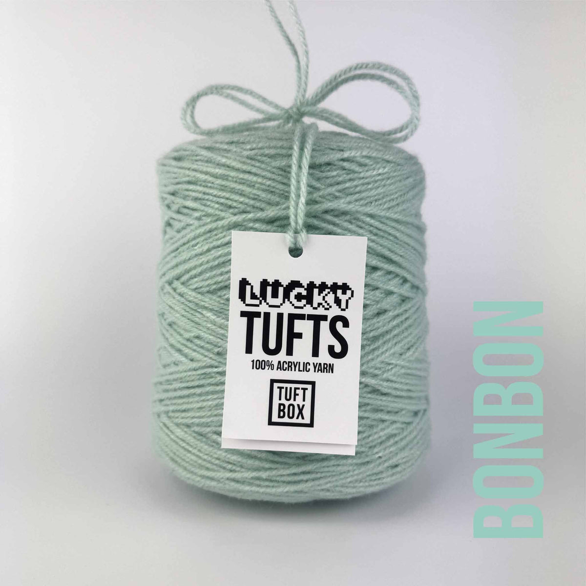 A cone of Lucky Tufts™ acrylic tufting and punch needle yarn in the colour Bonbon. A high contrast pale green.