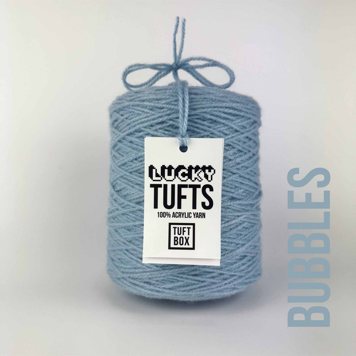 A cone of Lucky Tufts™ acrylic tufting and punch needle yarn in the colour Bubbles. A bright blue and light grey.