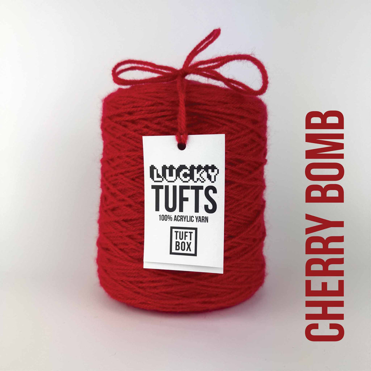 A cone of Lucky Tufts™ acrylic tufting and punch needle yarn in the colour Cherry Bomb a vibrant red 