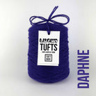 A cone of Lucky Tufts™ acrylic tufting and punch needle yarn in the colour Daphne. A dark indigo.