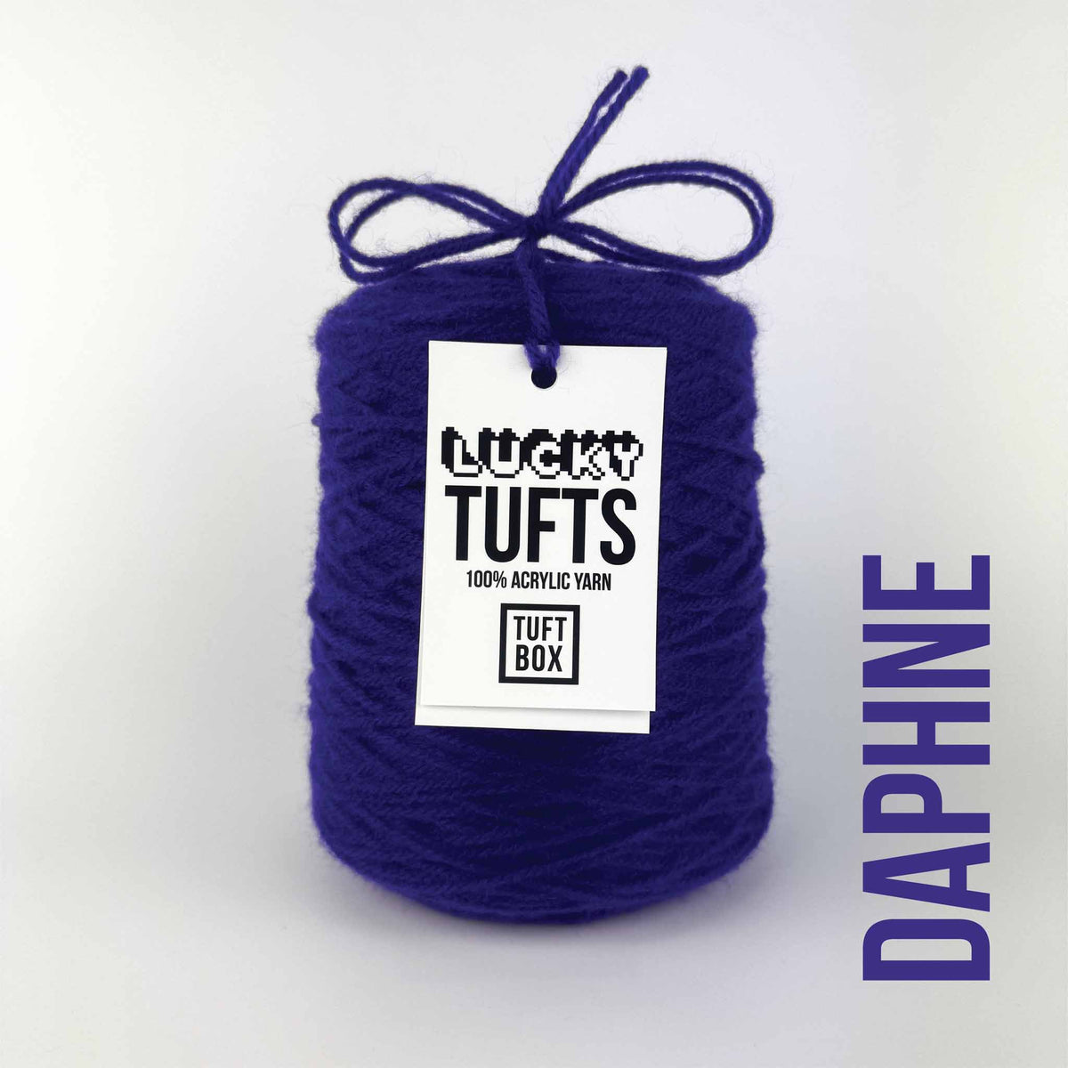 A cone of Lucky Tufts™ acrylic tufting and punch needle yarn in the colour Daphne. A dark indigo.