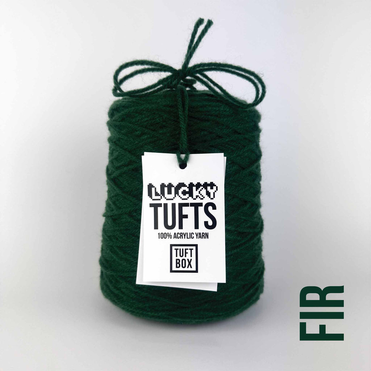 A cone of Lucky Tufts™ acrylic tufting and punch needle yarn in the colour Fir. A deep and dark green.
