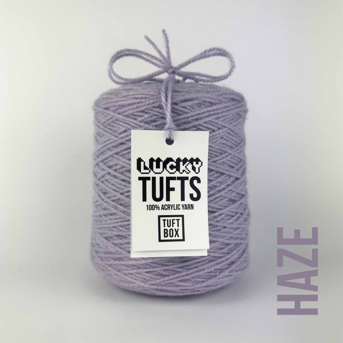 A cone of Lucky Tufts™ acrylic tufting and punch needle yarn in the colour Haze. A light purple with blue tones.