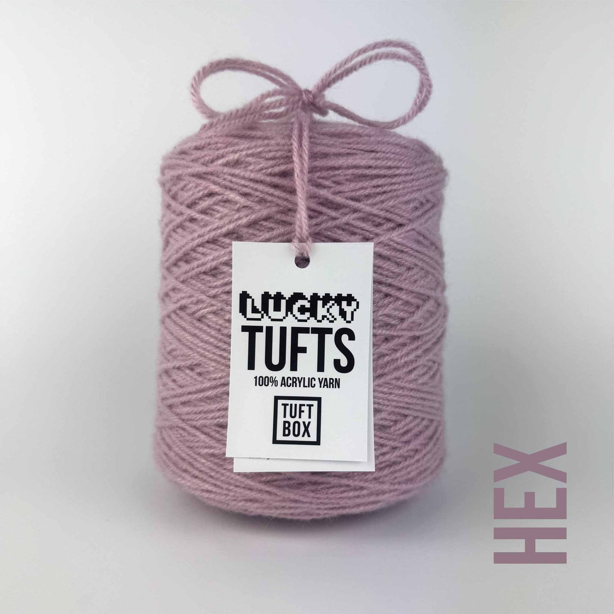 A cone of Lucky Tufts™ acrylic tufting and punch needle yarn in the colour Hex. A washed pink with a grey tone.
