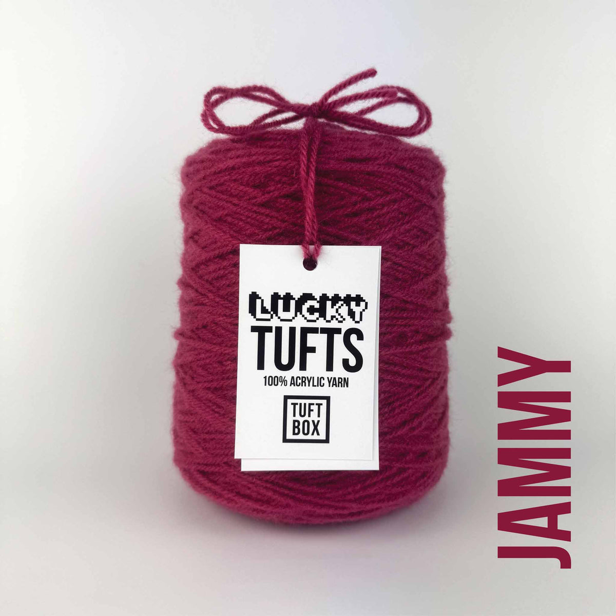 A cone of Lucky Tufts™ acrylic tufting and punch needle yarn in the colour Jammy, a thick and dark red.