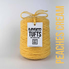 A cone of Lucky Tufts™ acrylic tufting and punch needle yarn in the colour Peaches & Cream a very light pastel peach 
