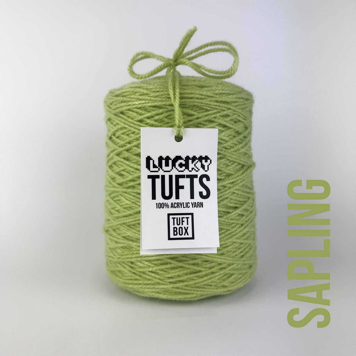 A cone of Lucky Tufts™ acrylic tufting and punch needle yarn in the colour Sapling. A soft and bright green.