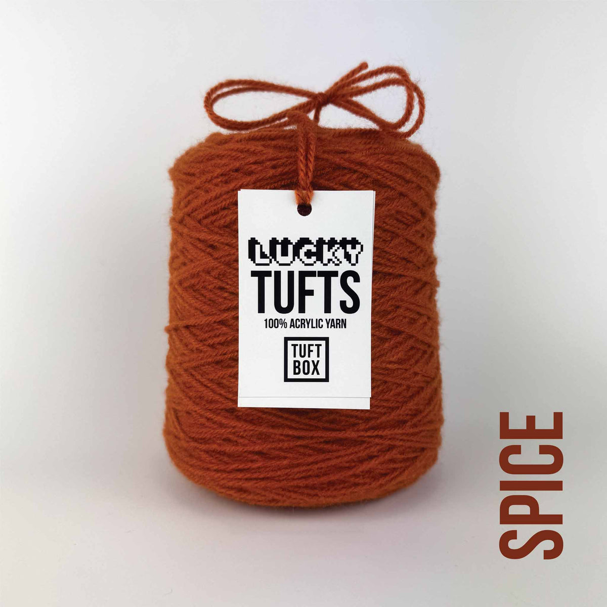 A cone of Lucky Tufts™ acrylic tufting and punch needle yarn in the colour Spice a warm burnt red orange 