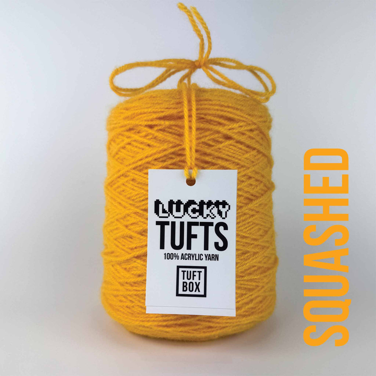A cone of Lucky Tufts™ acrylic tufting and punch needle yarn in the colour Squashed a vibrant yellow orange