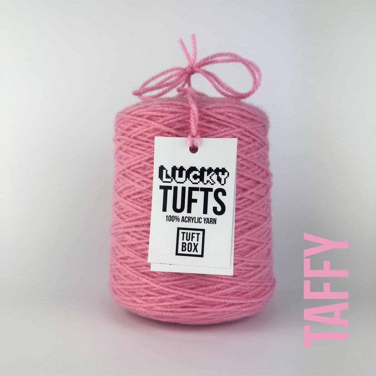 A cone of Lucky Tufts™ acrylic tufting and punch needle yarn in the colour Taffy. A bright pink.