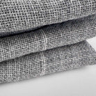 Stack of Grey Primary Rug Tufting Fabric fabric swatches on a white background