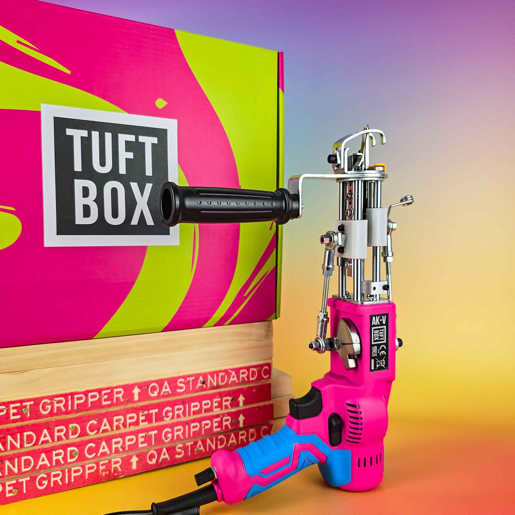 Hot pink AKV AK5 rug tufting machine with tuftbox box and tufting frame with carpet grippers on colourful rainbow ombre background